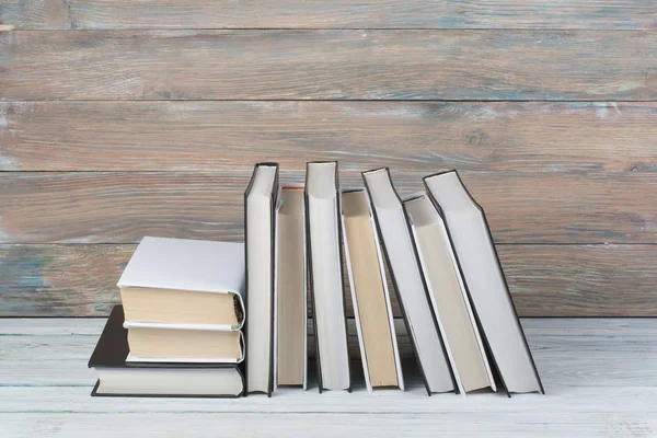 Open boeken over houten tafel, zwarte bord achtergrond. Terug naar school. Onderwijs bedrijfsconcept. — Stockfoto