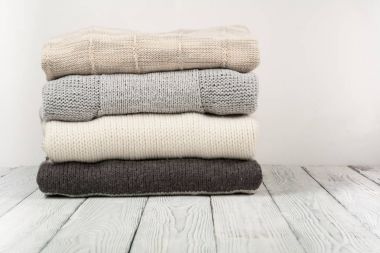 Örgü yün kazaklar. Ahşap arka planda örülmüş kış kıyafetleri, kazaklar, örgü giysileri, metin için yer..