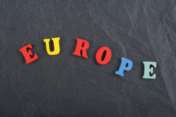 Europa woord op de achtergrond zwart bestuur samengesteld uit kleurrijke abc alfabet houten drukletters, kopie ruimte voor de advertentietekst. Engels concept leren. — Stockfoto
