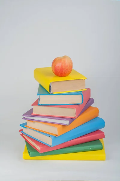 Стек барвистих реальних книг, яблуко на білому тлі, частковий вид. Повернутися до школи, Копіювати простір. Освіта  . — стокове фото