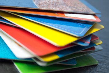 Siyah arka planda yığınla banka kartı var. Kara Cuma, indirim.