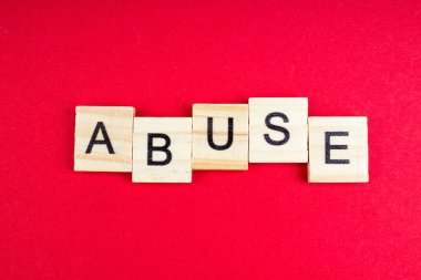 Kırmızı arkaplanda tahta blok harflerinden oluşturulan küfürlü sözcük, reklam metni için boşluk kopyala.