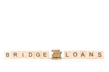 Bridge loans- word composed fromwooden blocks letters on White background, copy space for ad text. clipart