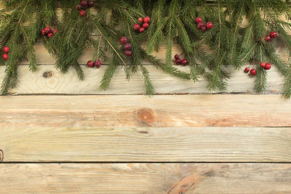 Kerst samenstelling van dennen takken en bessen van viburnum op een houten achtergrond. Bovenaanzicht met kopieerruimte. — Stockfoto