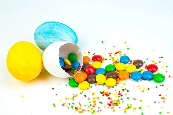 Buona Pasqua. Uovo di Pasqua rotto con decorazioni di caramelle multicolori. su sfondo bianco. Copia spazio per testo — Foto Stock