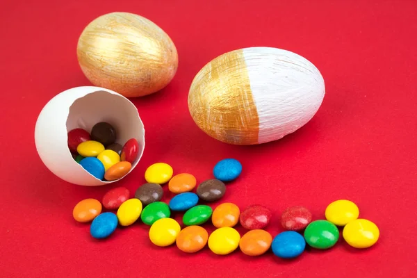 Buona Pasqua. Uovo di Pasqua rotto con decorazioni di caramelle multicolori. su sfondo rosso. Copia spazio per testo — Foto Stock
