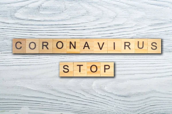 Coronavirus. Ahşap blokta ve ahşap masada yazılı kelimeleri durdur. en üstteki görünüm.