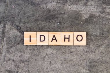 Idaho kelimesi tahta blokta, gri beton arka planda yazılmış. Üst görünüm.