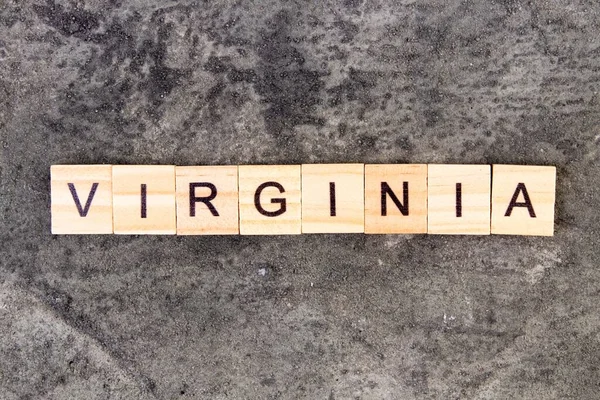 Virginia word written on wood block, on gray concrete background. Top view. — Stock Photo, Image