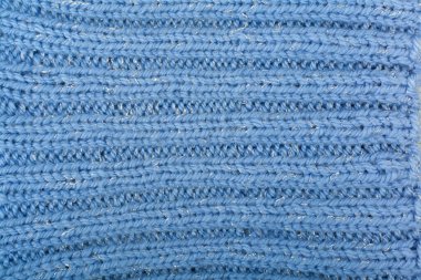 Süveter ya da atkı kumaş dokusu büyük örgü. Örülmüş forma ve kabartma desenli. Örgü ören örgüler. Yün el yapımı makine, el yapımı, mavi.