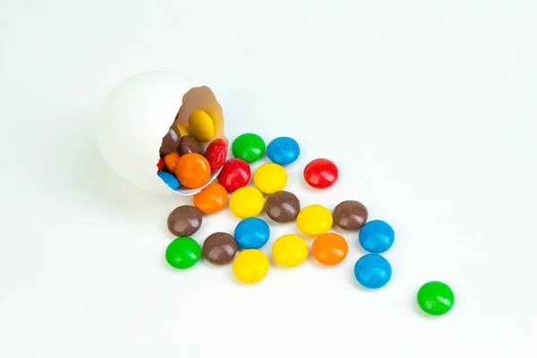 Buona Pasqua. Uovo di Pasqua rotto con decorazioni di caramelle multicolori. su sfondo bianco. Copia spazio per testo — Foto Stock