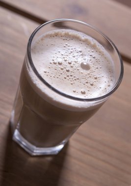 Ahşap bir masada bir bardak kapuçino.