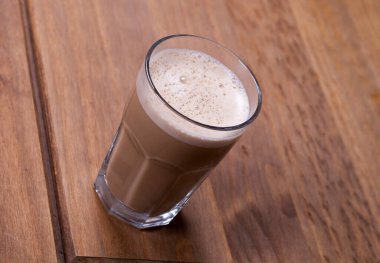 Ahşap bir masada bir bardak kapuçino.