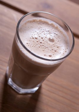 Ahşap bir masada bir bardak kapuçino.