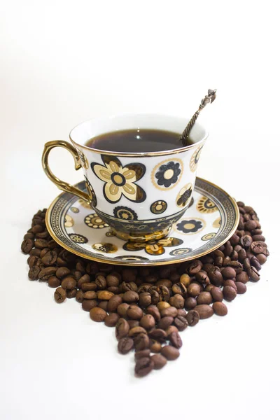 Uma xícara de café e café em um fundo branco — Fotografia de Stock