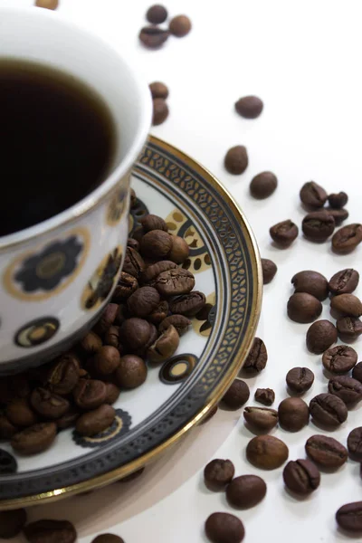 Een kopje koffie en koffiebonen op een witte achtergrond — Stockfoto