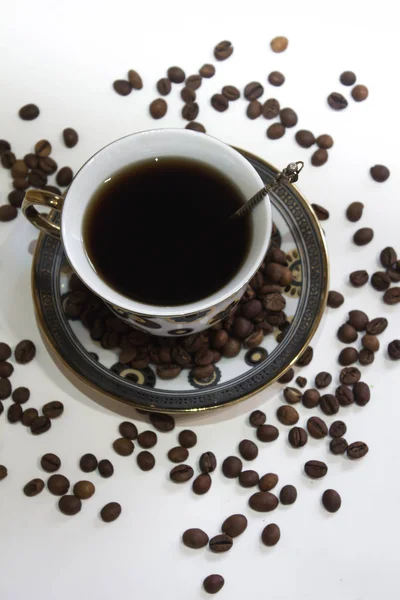 Een kopje koffie en koffiebonen op een witte achtergrond — Stockfoto