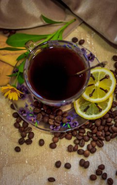 Kahve natürmort, güçlü kahve kokusu. Bir fincan kahve ve kahve taneleri nazik bir arka plan üzerinde