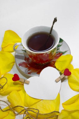 Bir fincan çay sarı gül yaprakları ile