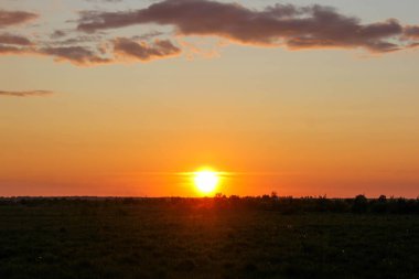 Olağandışı yaz günbatımı bir alan içinde bir köy