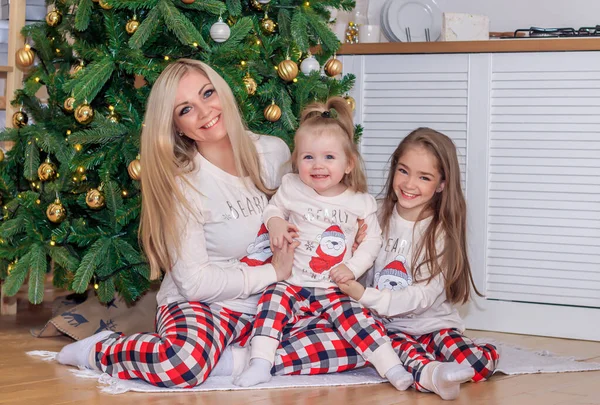 Mutter und Tochter am Weihnachtsbaum. Weihnachtszeit. Schwestern. Frohe Weihnachten und frohe Feiertage fröhliche Mutter und ihre süßen Töchter tauschen Geschenke. — Stockfoto