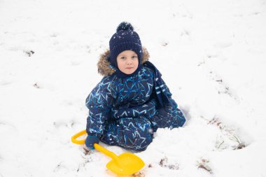Küçük çocuk kış mevsiminde parkta yürüyor.