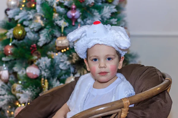 家でクリスマスツリーの下のウサギの衣装の小さな男の子 — ストック写真