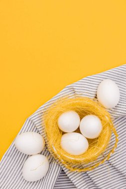 Sarı arka planda mutfak havlusunda tavuk yumurtası. Çiftlik ve ev ürünleri kavramı. Metin için yeri olan pankart. Yiyecek.