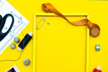 Dikiş düzeni. Dikiş işi, el işi, dikiş ve terzilik konsepti. İplik makaralı ve düğmeli kutu. Aksesuar dikme konsepti. Düz yerde, üst tarafta. Metin için dikiş ve dikiş çerçevesi.