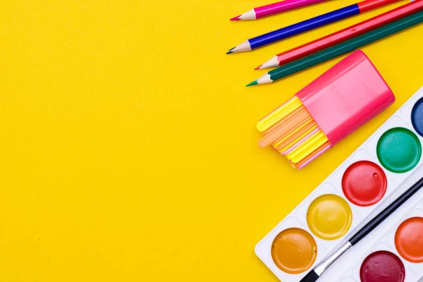 Office supplies on a yellow background. Various school supplies on a bright yellow background. Text frame with office supplies. The layout of the school. Welcome back to school. Concept of advertising office supplies. Flat lay with space for text.