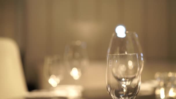 Обстановка столу, ресторанна сервіровка, інтер'єр ресторану, порожні окуляри на білому столі, ряд порожніх келихів шампанського. Фуршет, кейтеринг. Окуляри для шампанського або вина . — стокове відео