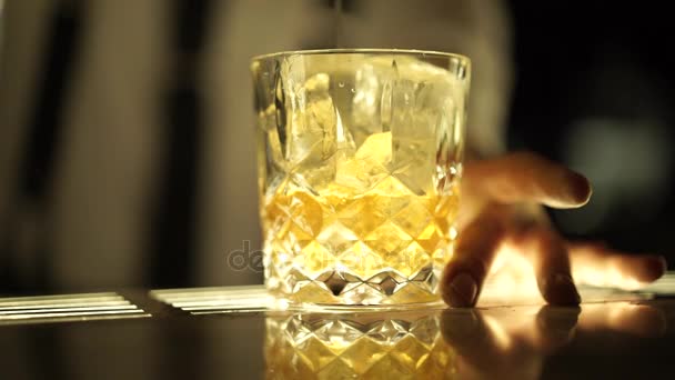 Un vaso de bebida alcohólica y cubitos de hielo — Vídeo de stock