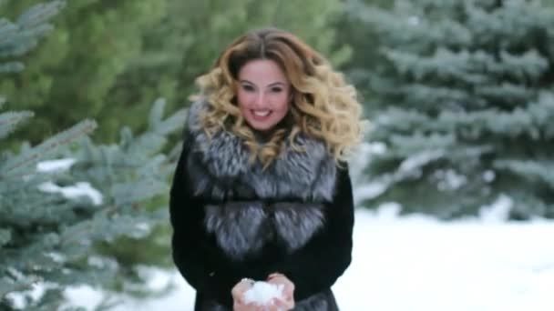 La chica tira la nieve y es feliz — Vídeo de stock