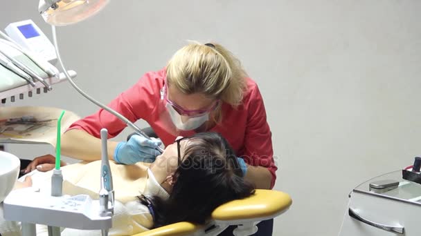 Dentista perforando dientes de pacientes en la clínica — Vídeo de stock