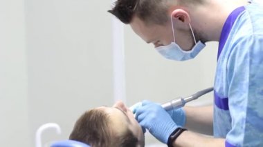 dişçi klinikte diş hasta muamelesi yapıyor.
