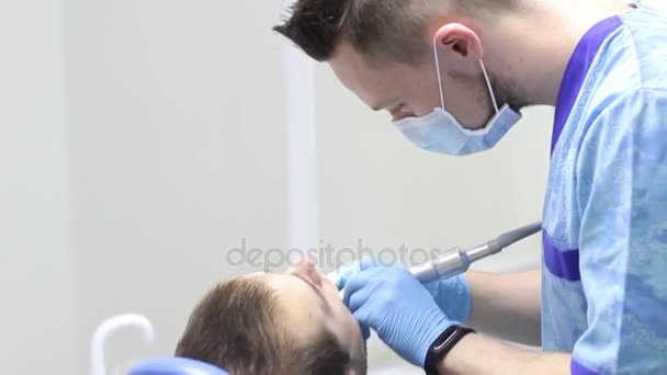 Dentista trata paciente dente na clínica — Vídeo de Stock