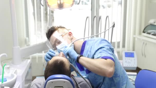 Lékař zkontroluje ústní dutiny, čistí ji a léčí — Stock video