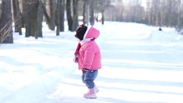 Un bambino piccolo che cammina su una strada forestale invernale — Video Stock