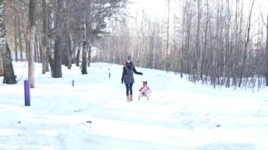 Anne bebeğini bir kızak üzerinde rulo.