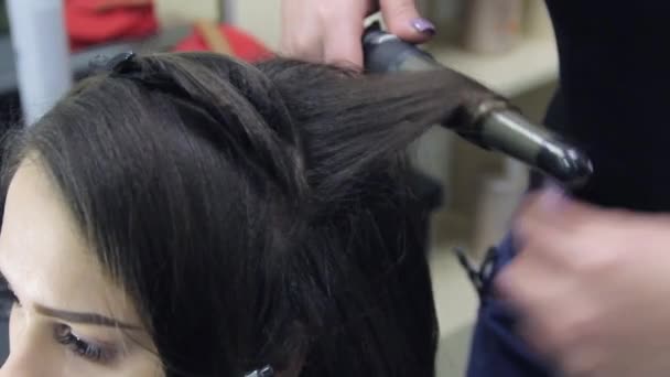 Estilista rizando pelo para mujer. Chica cuidar de su peinado — Vídeo de stock