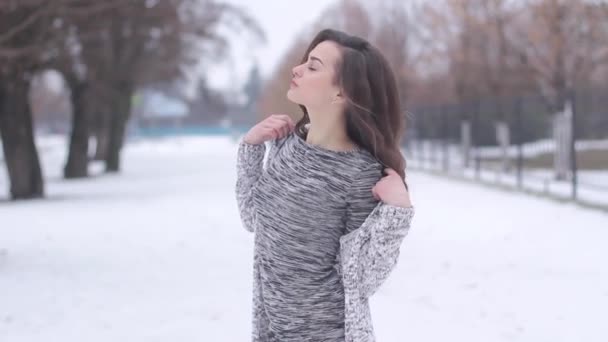 Jonge vrouw poseren in stijlvolle kleding buiten in de winter — Stockvideo