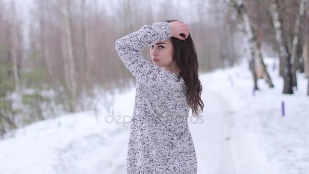Молодая женщина позирует в стильной одежде на улице зимой — стоковое видео
