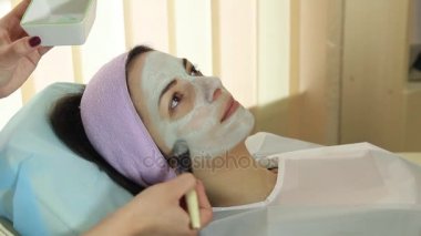 Yüz maskesi bulunan bir spa genç kadın. Spa salonda kadın