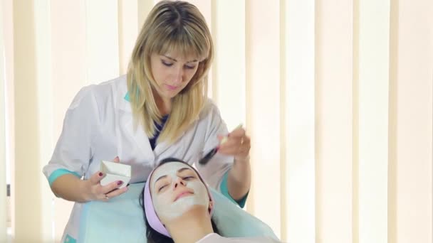 Junge Frau in einem Wellnessbereich mit Gesichtsmaske. Frau im Wellness-Salon — Stockvideo