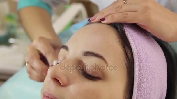 Woman getting face treatment in medical spa center, cleansing with cosmetic cotton pads — Stock Video
