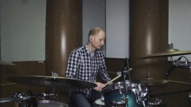 Gömlek ve pantolon davul kiti arkasındaki yakışıklı adam bateri çalıyor