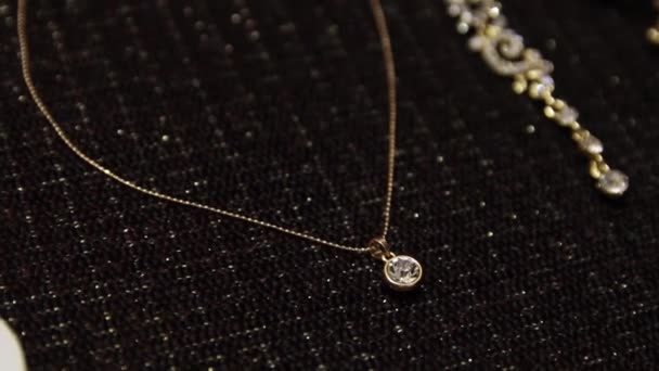 Collares de oro, pendientes y joyas de primer plano sobre fondo oscuro — Vídeo de stock