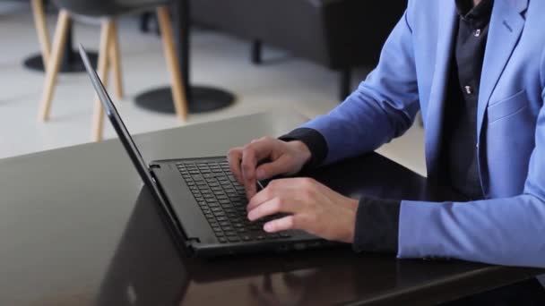 Молодой бизнесмен работает за компьютером в кафе — стоковое видео