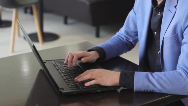 Joven hombre de negocios que trabaja en la computadora en la cafetería — Vídeos de Stock