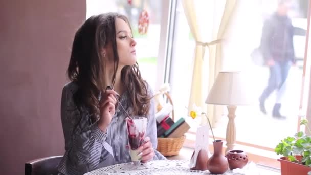 Hermosa chica está disfrutando de un delicioso postre en la cafetería — Vídeos de Stock